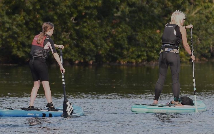 2 female paddleboarders, one a teenager the other an adult